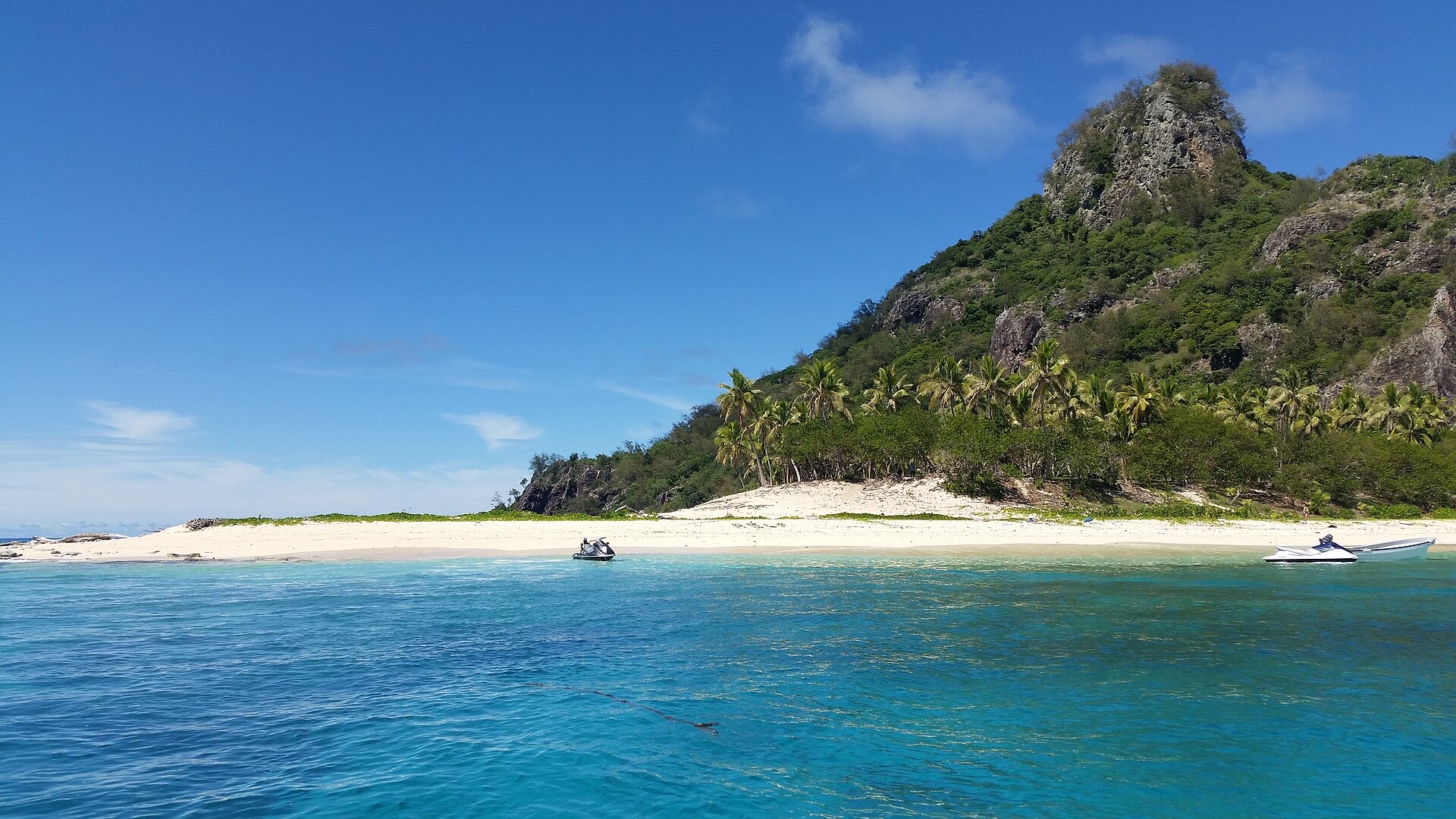 Monuriki Island in the Mamanuca group, with a white beach, a steep green hill and clear turquoise water
